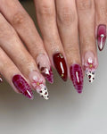 Handmade red press-on nails with floral designs, gold accents, and spring-inspired patterns.
