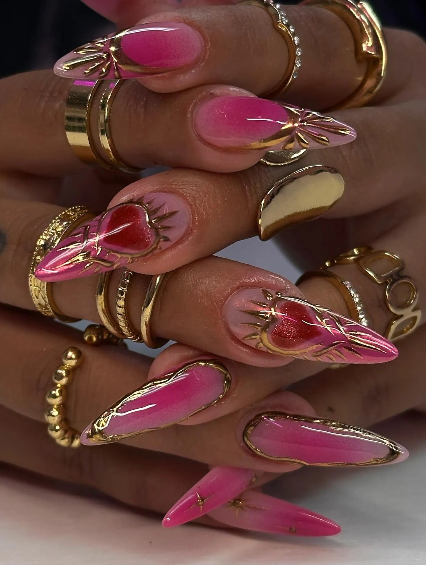 Handmade hot pink ombre press-on nails with gold chrome accents and sacred heart design