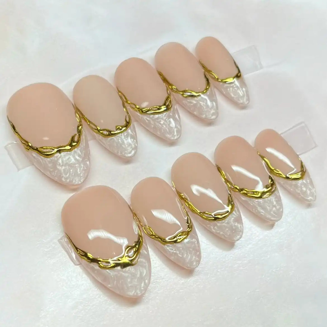 Handmade press-on nails with marble white French tips and gold border accents