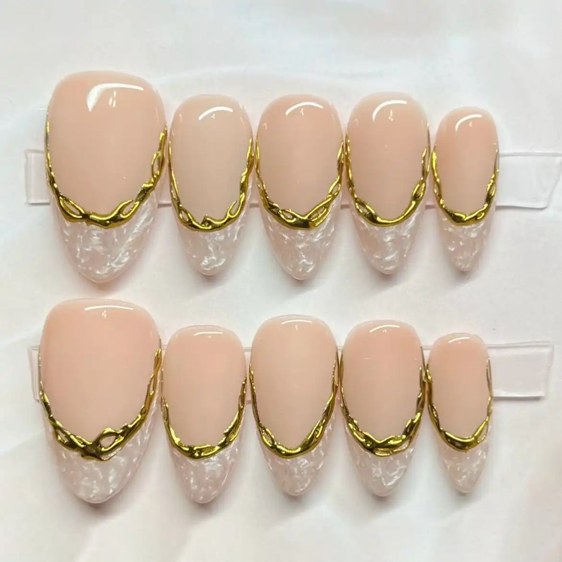 Handmade press-on nails with marble white French tips and gold border accents