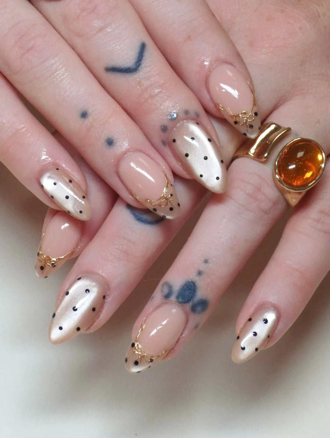 Handmade almond-shaped press-on nails with gold filigree and pearlescent polka dots