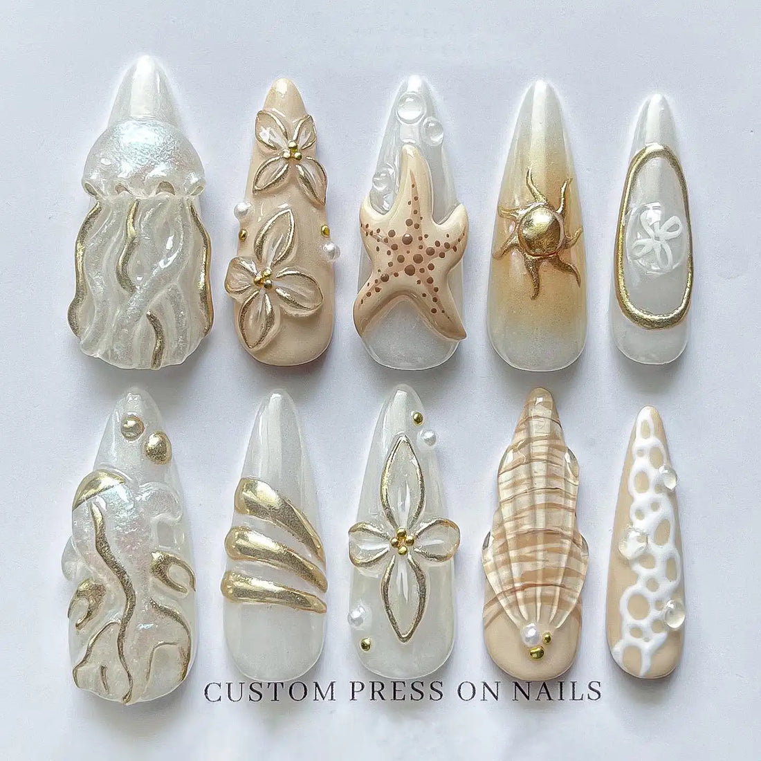 Handmade ocean-themed press-on nails with gold seashell, starfish, and jellyfish designs