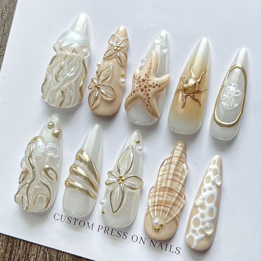 Handmade ocean-themed press-on nails with gold seashell, starfish, and jellyfish designs