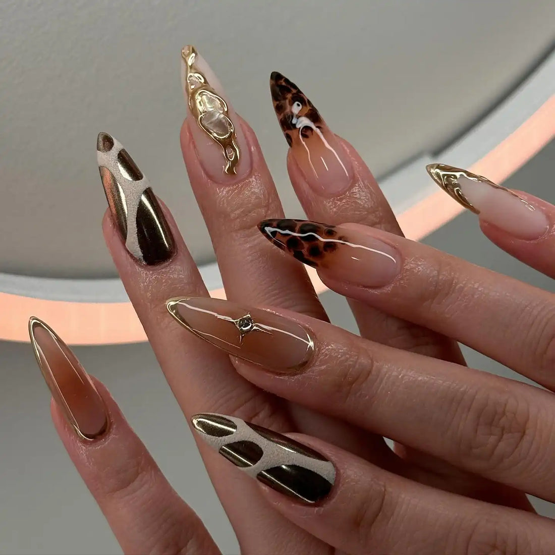 Handmade gold and brown press-on nails with abstract and tortoise shell designs.