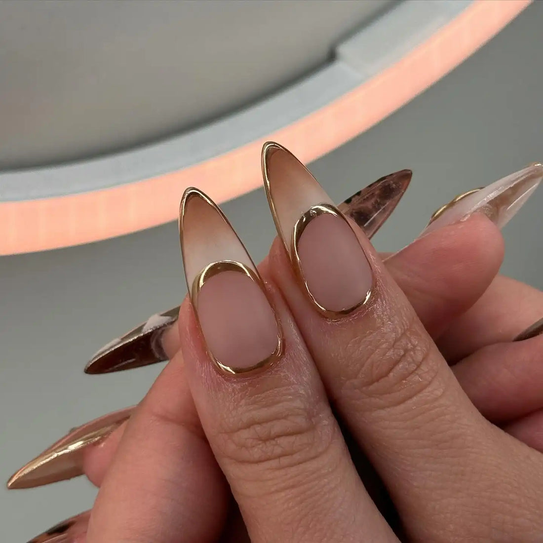 Handmade gold and brown press-on nails with abstract and tortoise shell designs.