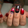 Handmade red and black press-on nails with chrome sacred heart and flame designs.