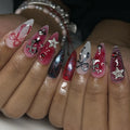 Handmade press-on nails with black, red, and chrome grunge designs, crosses, stars, and ribbons.