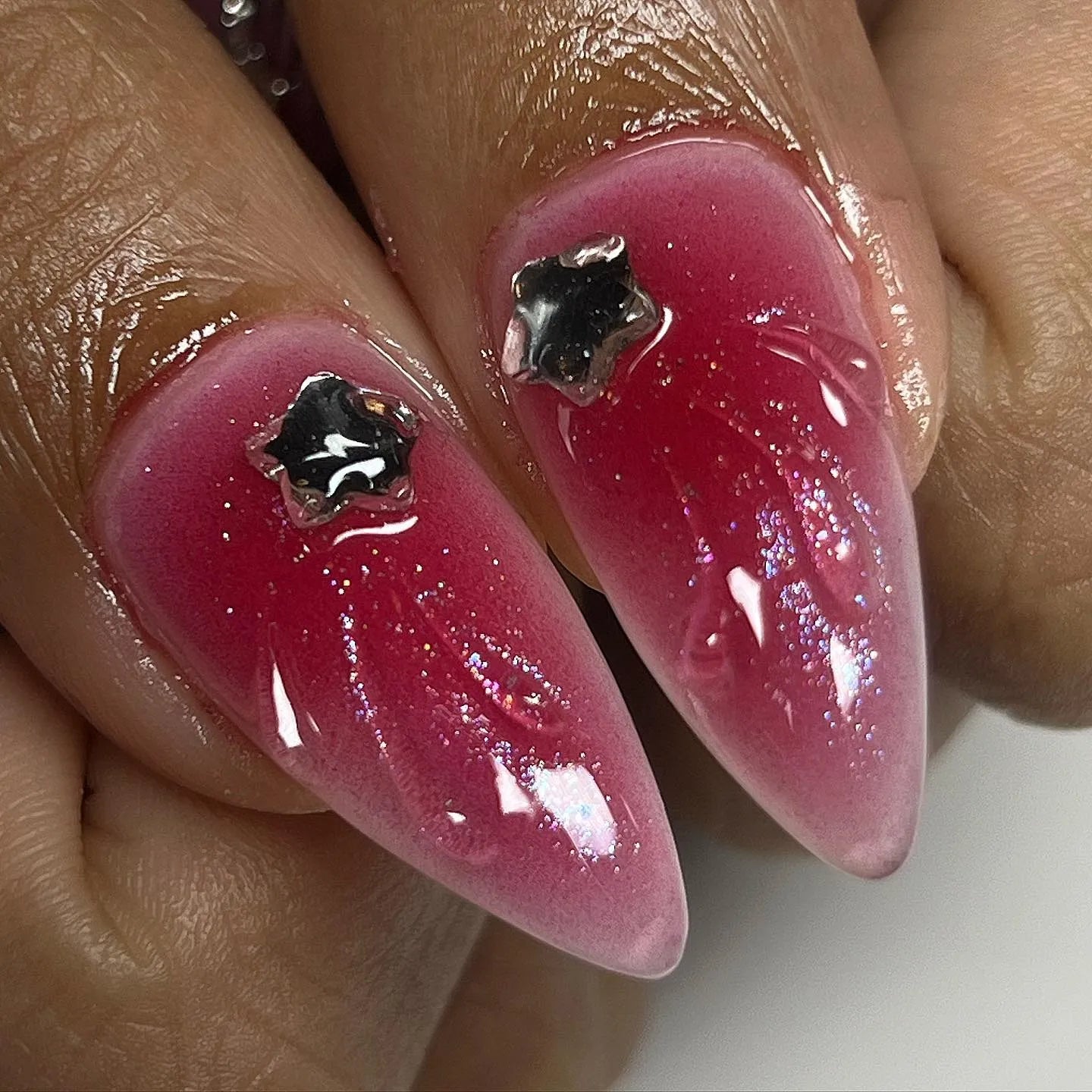 Handmade press-on nails with red ombre, glitter, and black star chrome accents