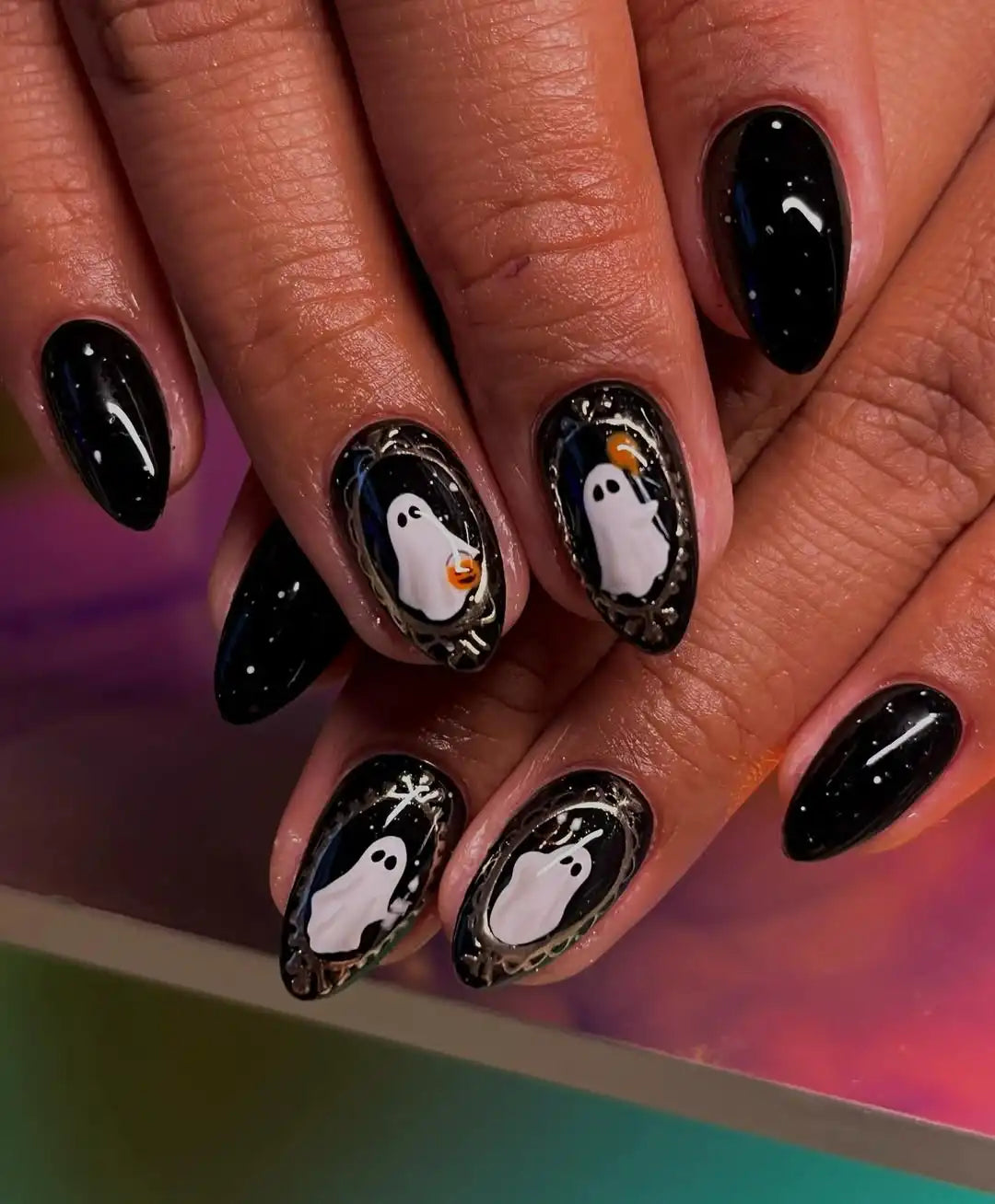Handmade Halloween press-on nails with cute ghost designs and metallic accents on black base