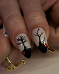 Handmade Halloween press-on nails with black tree, pumpkin accents, and almond shape