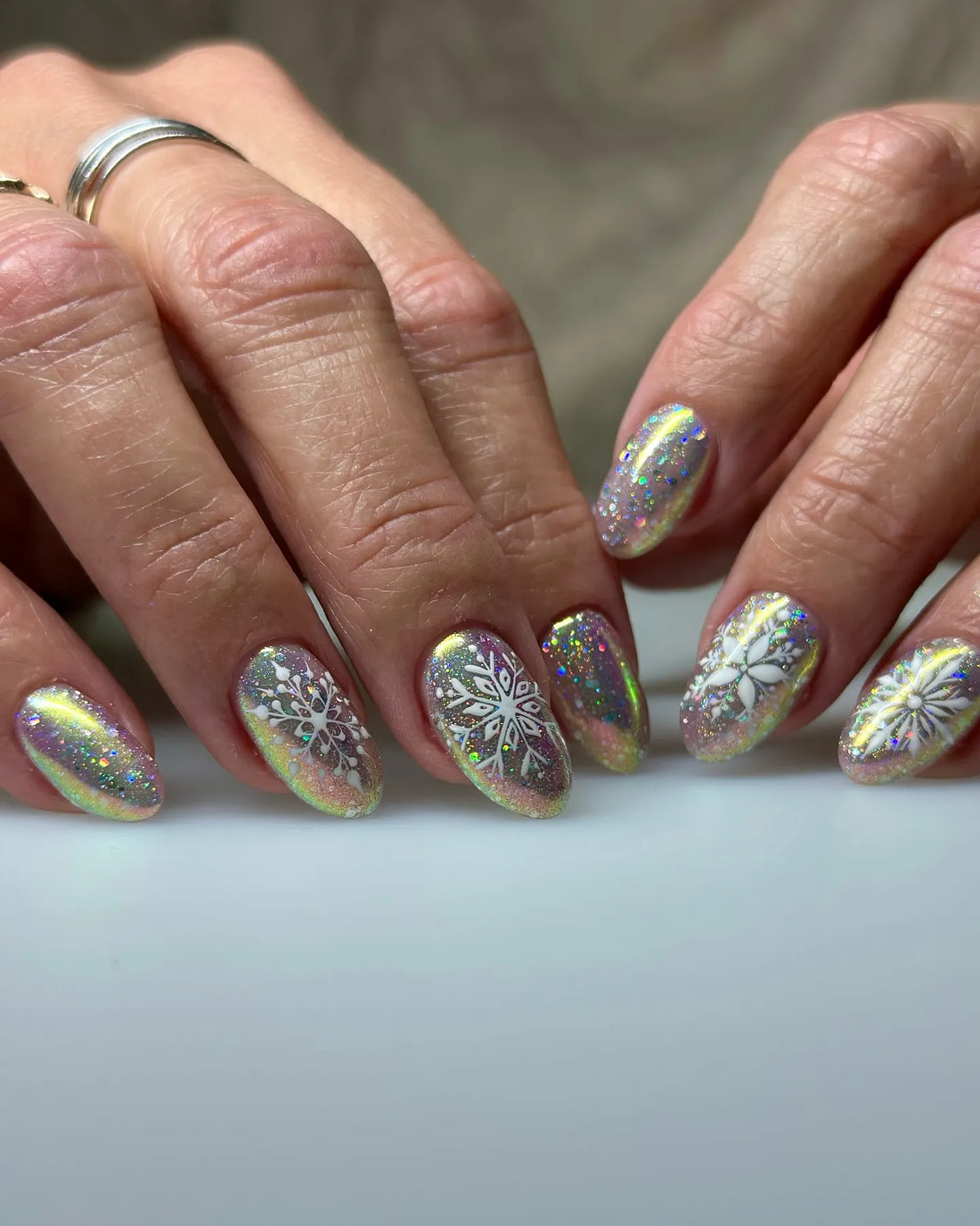 Handmade holographic glitter press-on nails with chrome snowflake winter designs