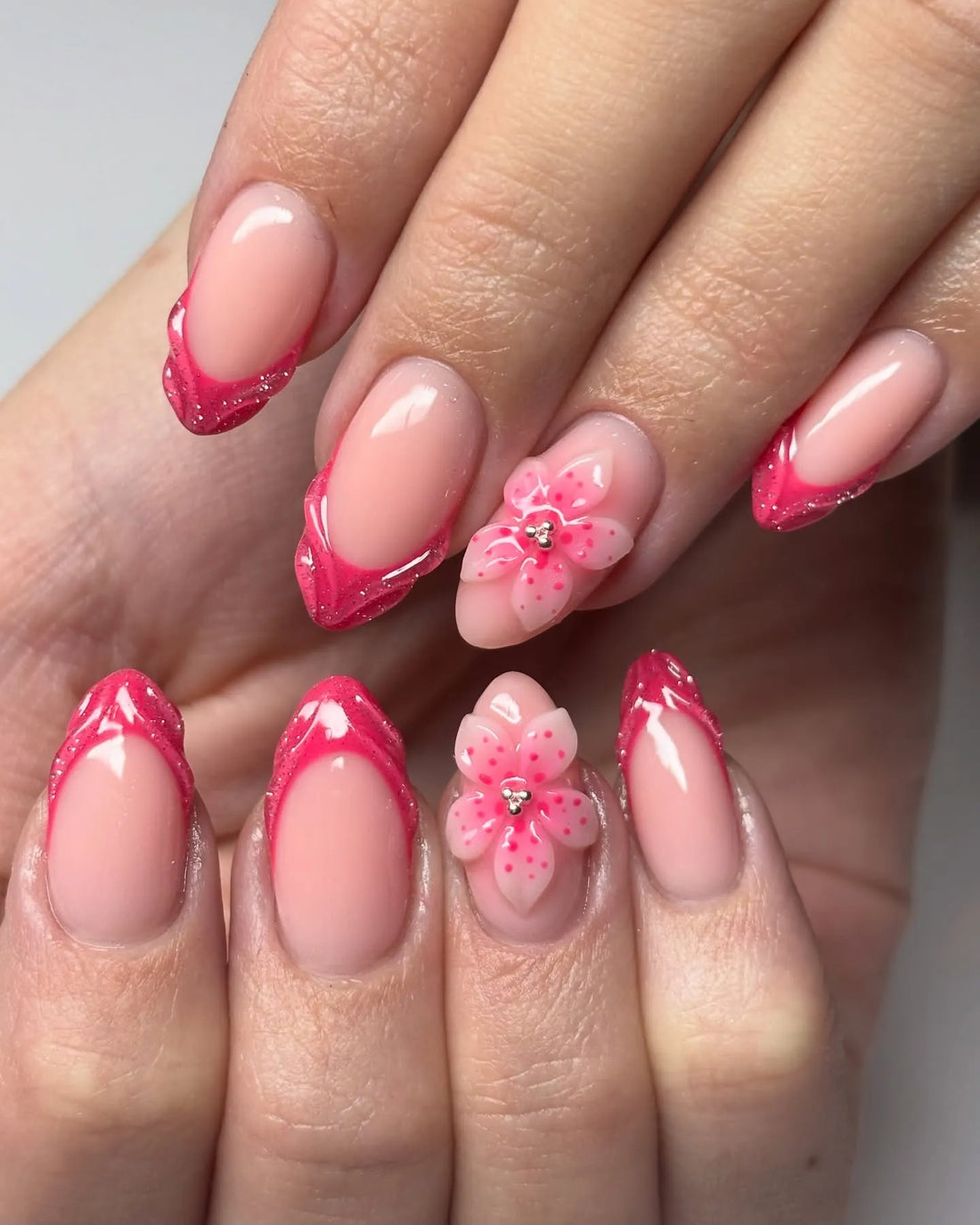 Handmade hot pink French tip press-on nails with 3D floral and glitter accents