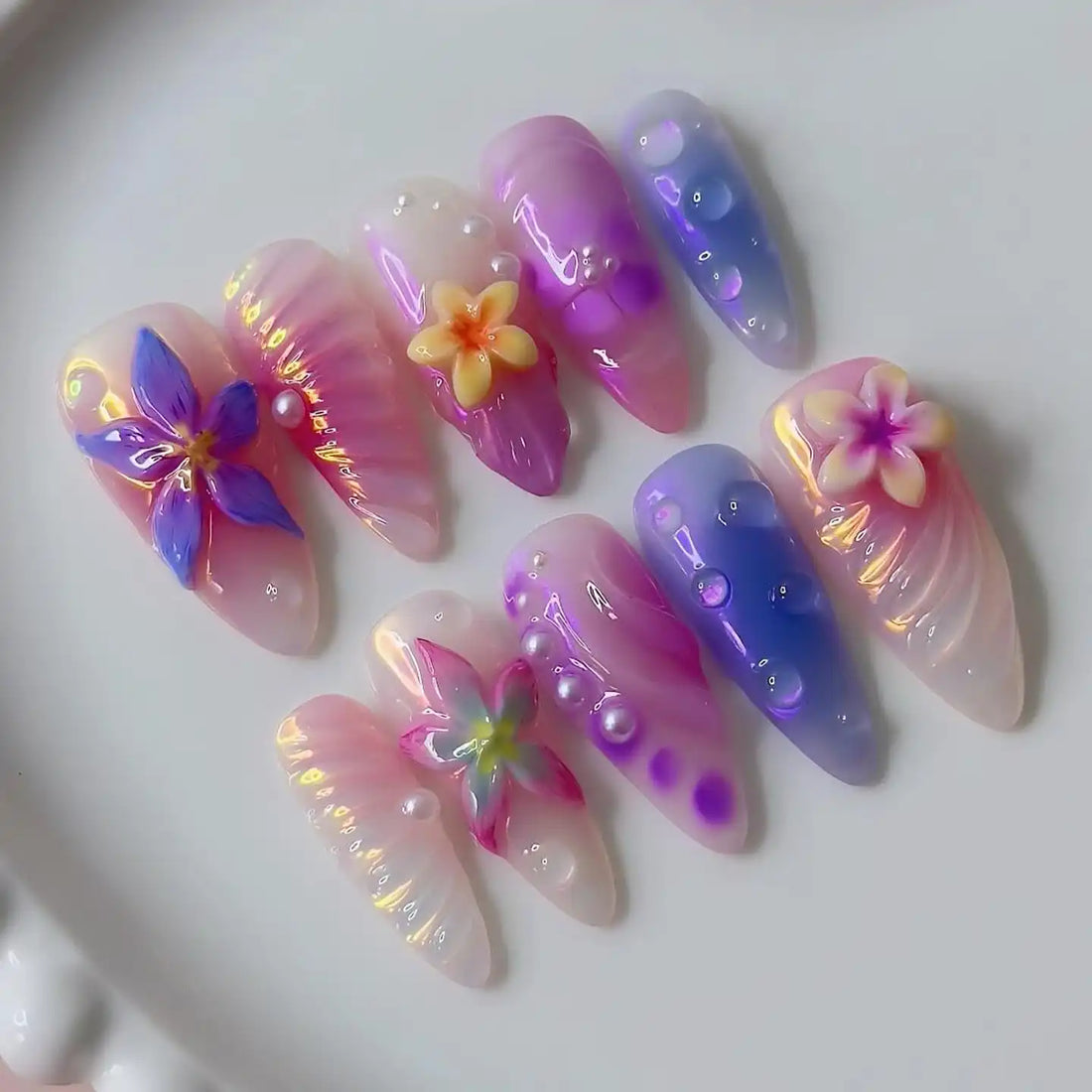 Handmade iridescent press-on nails with 3D floral designs, pearls, and gradient colors.