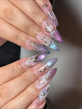 Handmade iridescent stiletto press-on nails with celestial moon and star nail art.