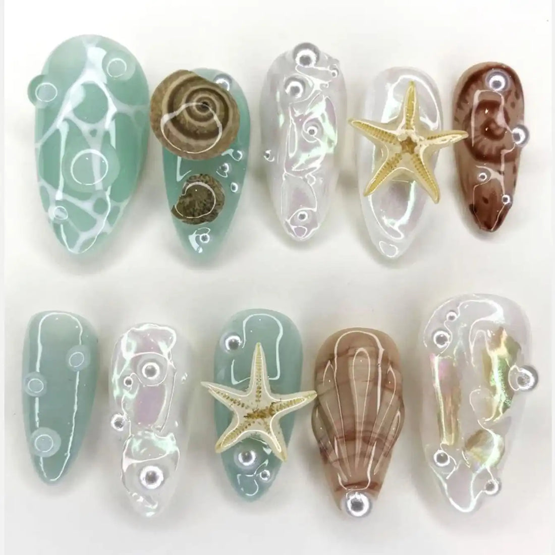 Handmade iridescent seafoam press-on nails with shells, starfish, and ocean-inspired accents