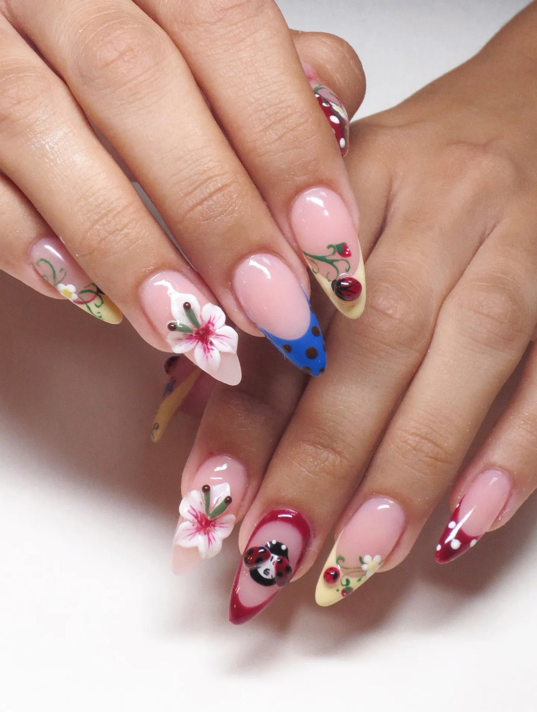 Handmade press-on nails with 3D floral, ladybug, and pink polka dot whimsical designs