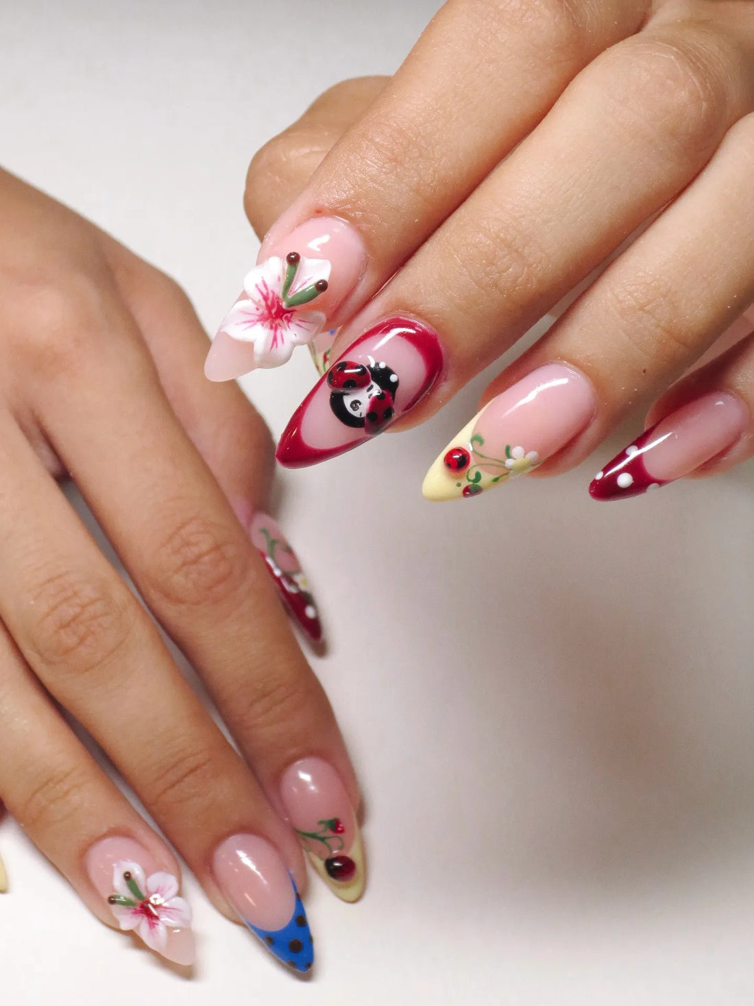 Handmade press-on nails with 3D floral, ladybug, and pink polka dot whimsical designs
