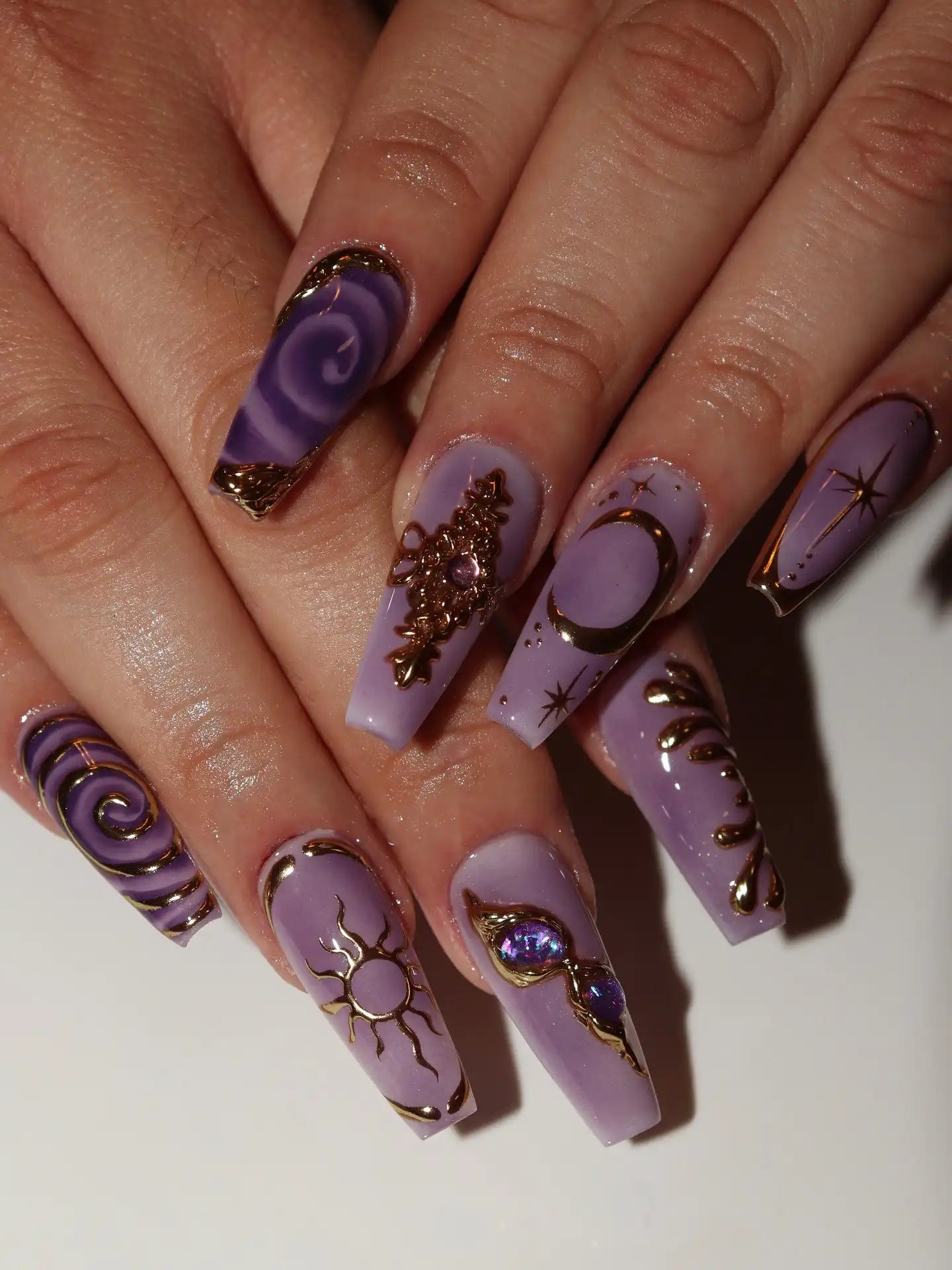 Handmade lavender press-on nails with gold celestial moon, sun, and star designs