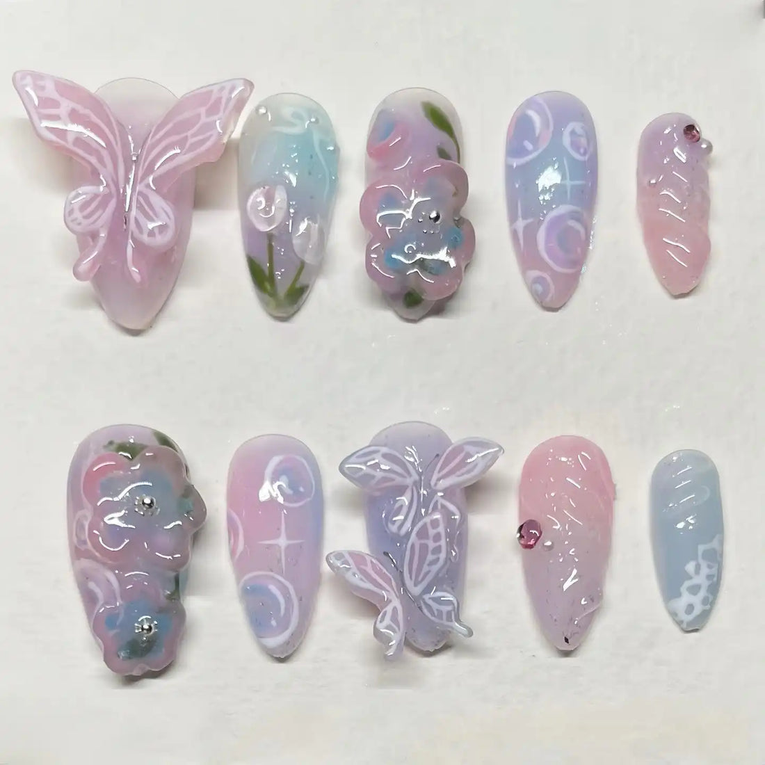 Handmade pastel press-on nails with 3D butterfly, floral, and nature-inspired designs.