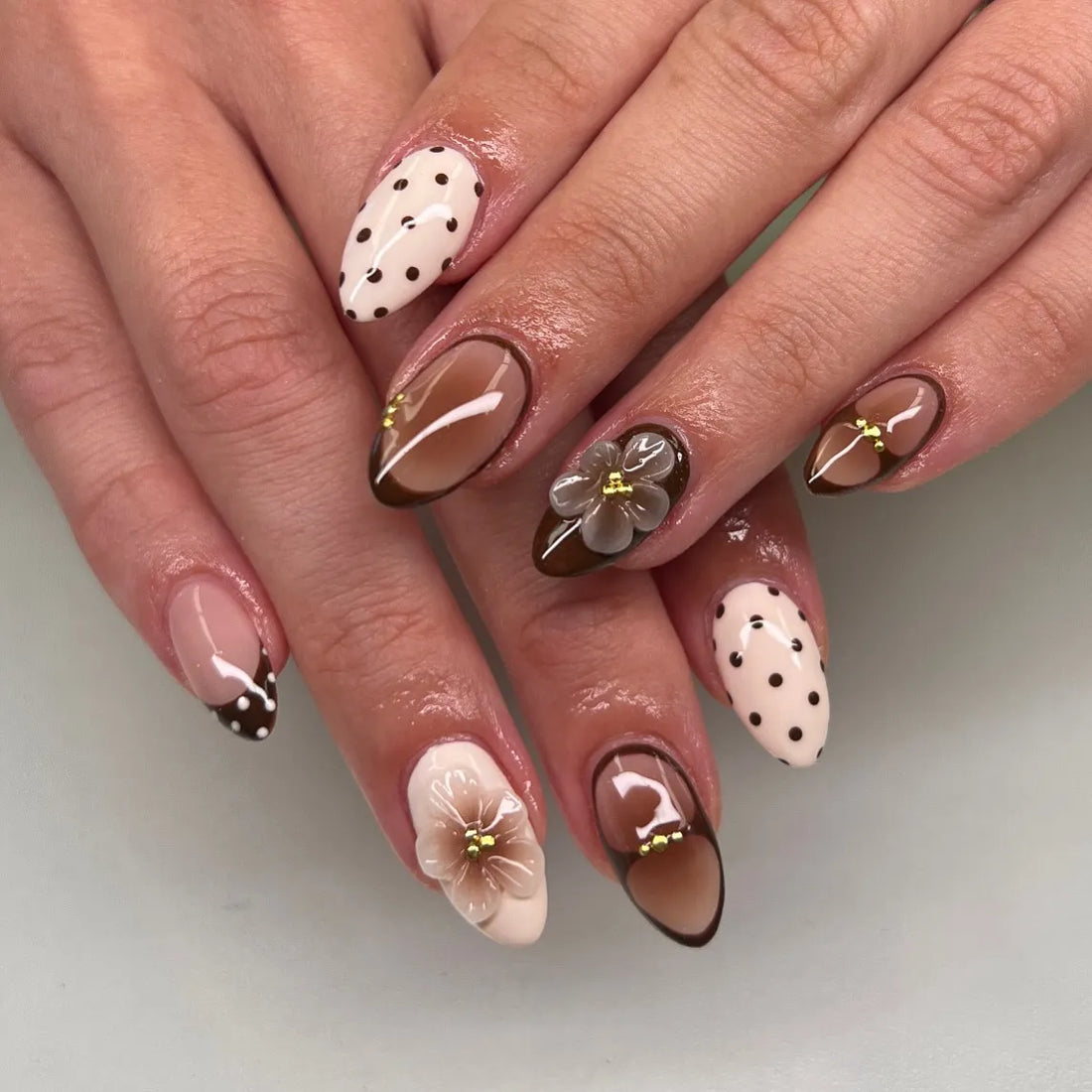 Handmade autumn press-on nails in brown and cream tones with 3D floral and polka dot designs