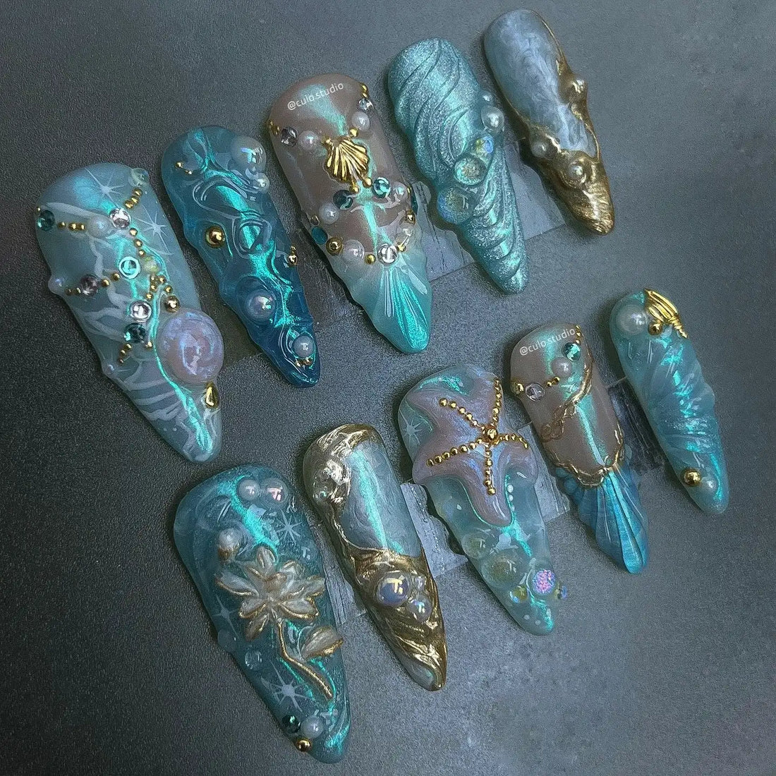 Handmade blue press-on nails with mermaid, starfish, shell, and pearl fantasy designs
