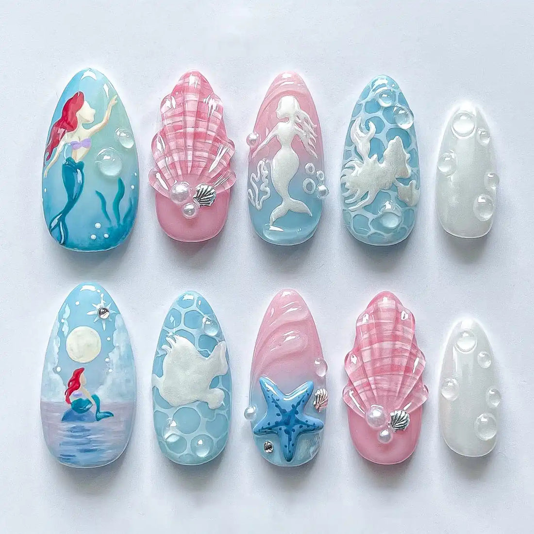 Handmade mermaid themed press-on nails with pink, blue, sea shell and ocean fantasy designs.