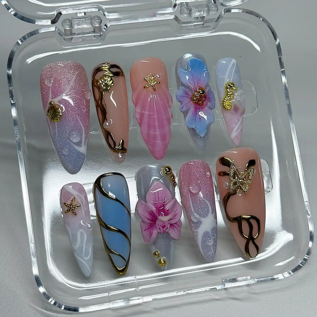 Handmade pastel press-on nails with seashell, starfish, seahorse, and floral ocean designs