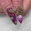 Handmade press-on nails with neon green, pink, and purple abstract drip design and 3D flower accent