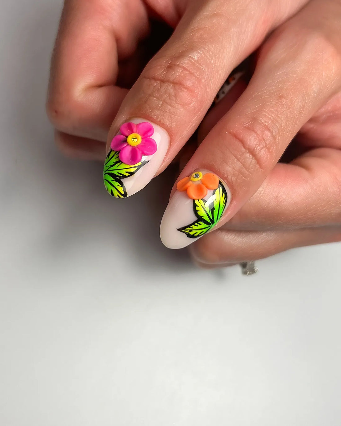 Handmade press-on nails with zebra and leopard prints, neon florals, and tropical leaf designs.