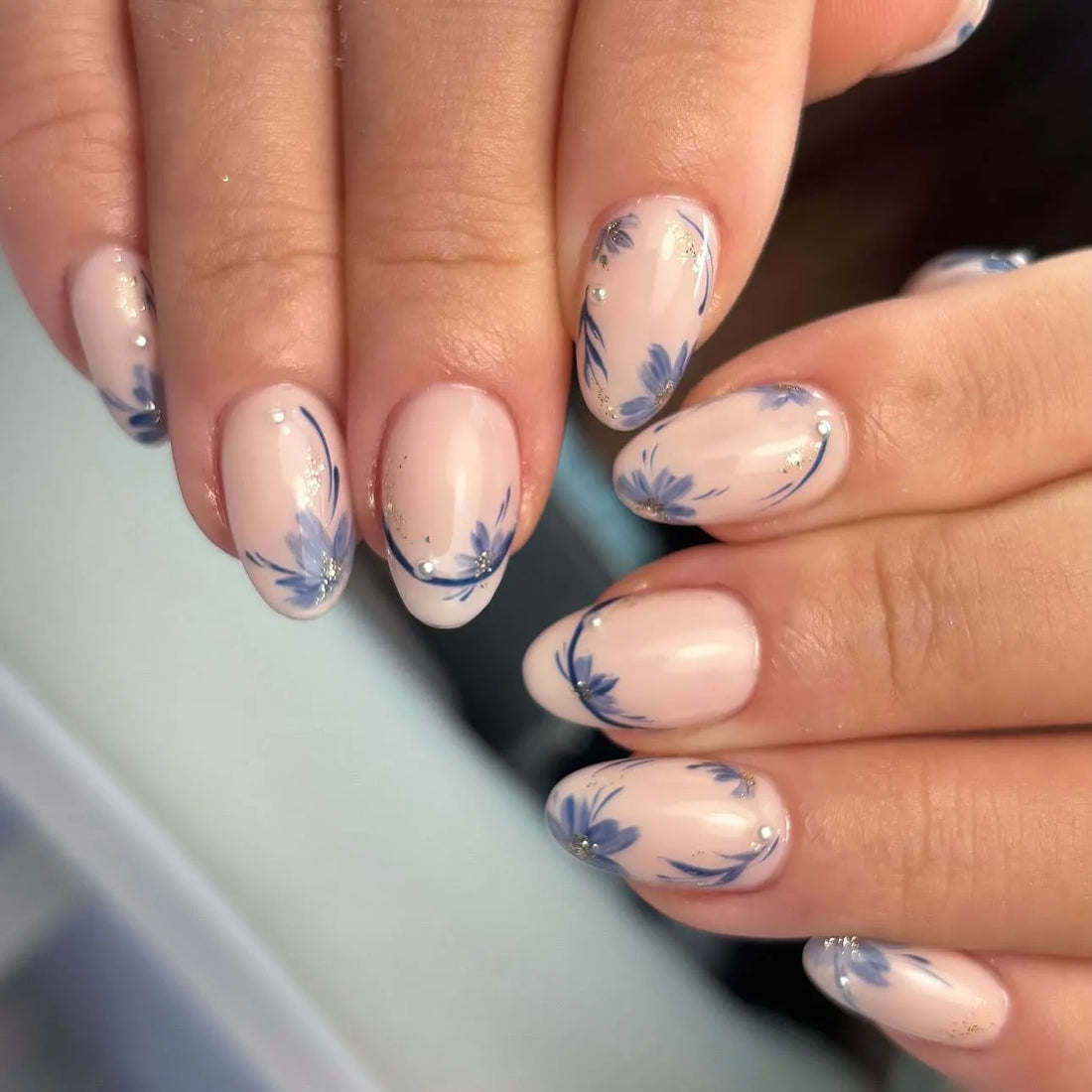 Handmade nude press-on nails with blue floral minimalist spring design and small gems