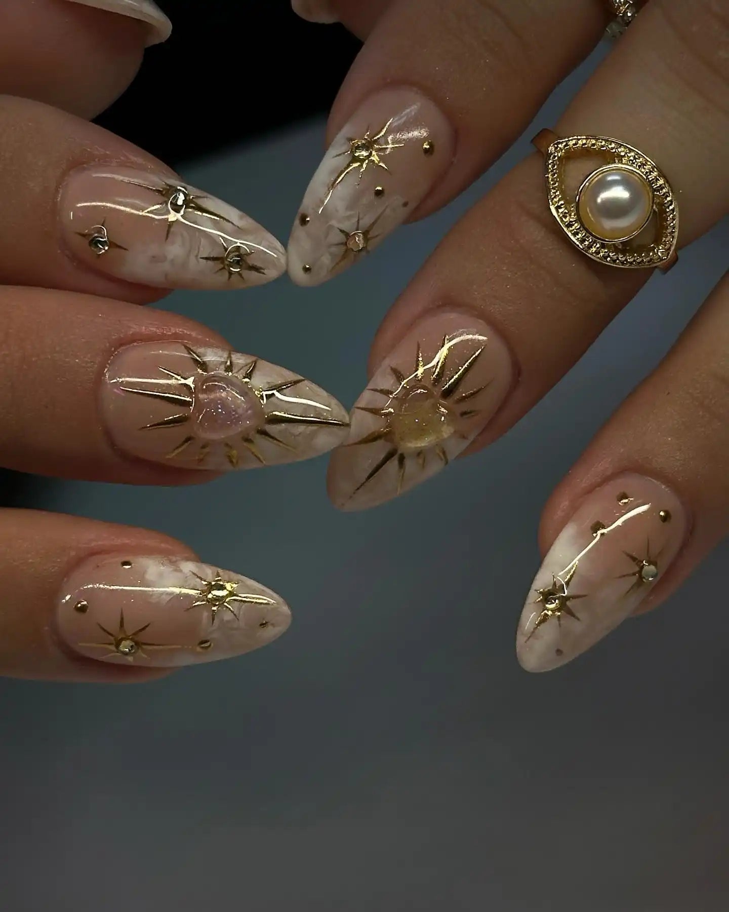 Handmade nude press-on nails with gold celestial heart and star charms, marble detail