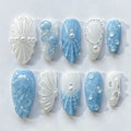 Handmade press-on nails with ocean blue and white jellyfish, pearl, and seashell designs.