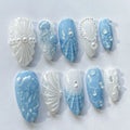 Handmade ocean blue and white press-on nails with 3D seashells, pearls, and jellyfish design