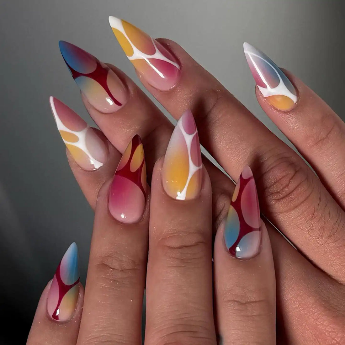 Handmade ombre gradient press-on nails with colorful abstract patterns, stiletto shape