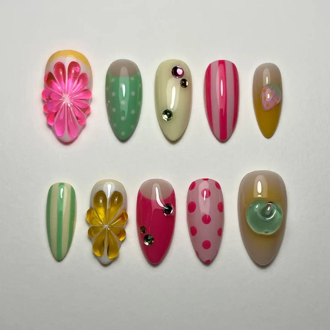 Handmade press-on nails with pastel stripes, polka dots, rhinestones, floral and citrus designs.