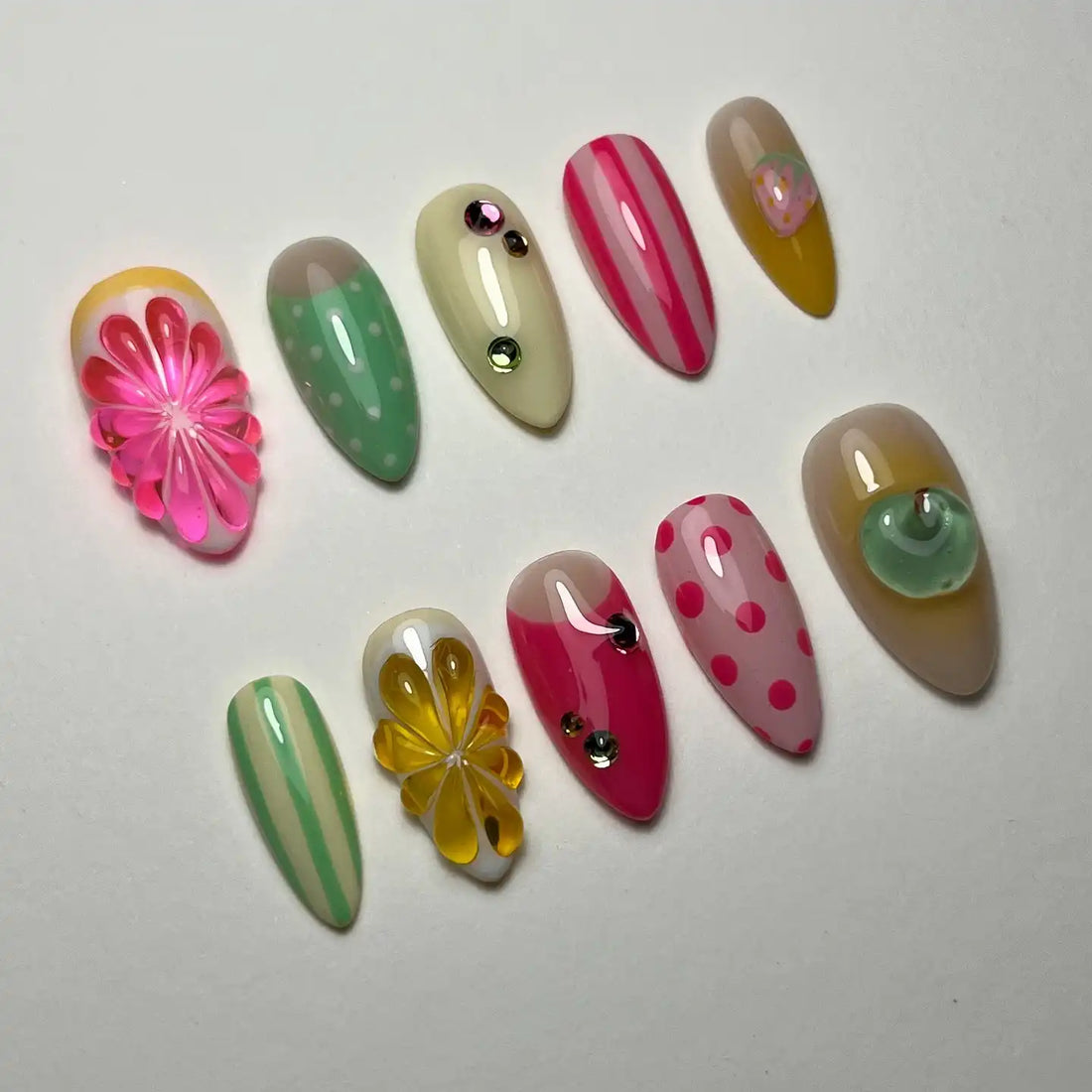 Handmade press-on nails with pastel stripes, polka dots, rhinestones, floral and citrus designs.