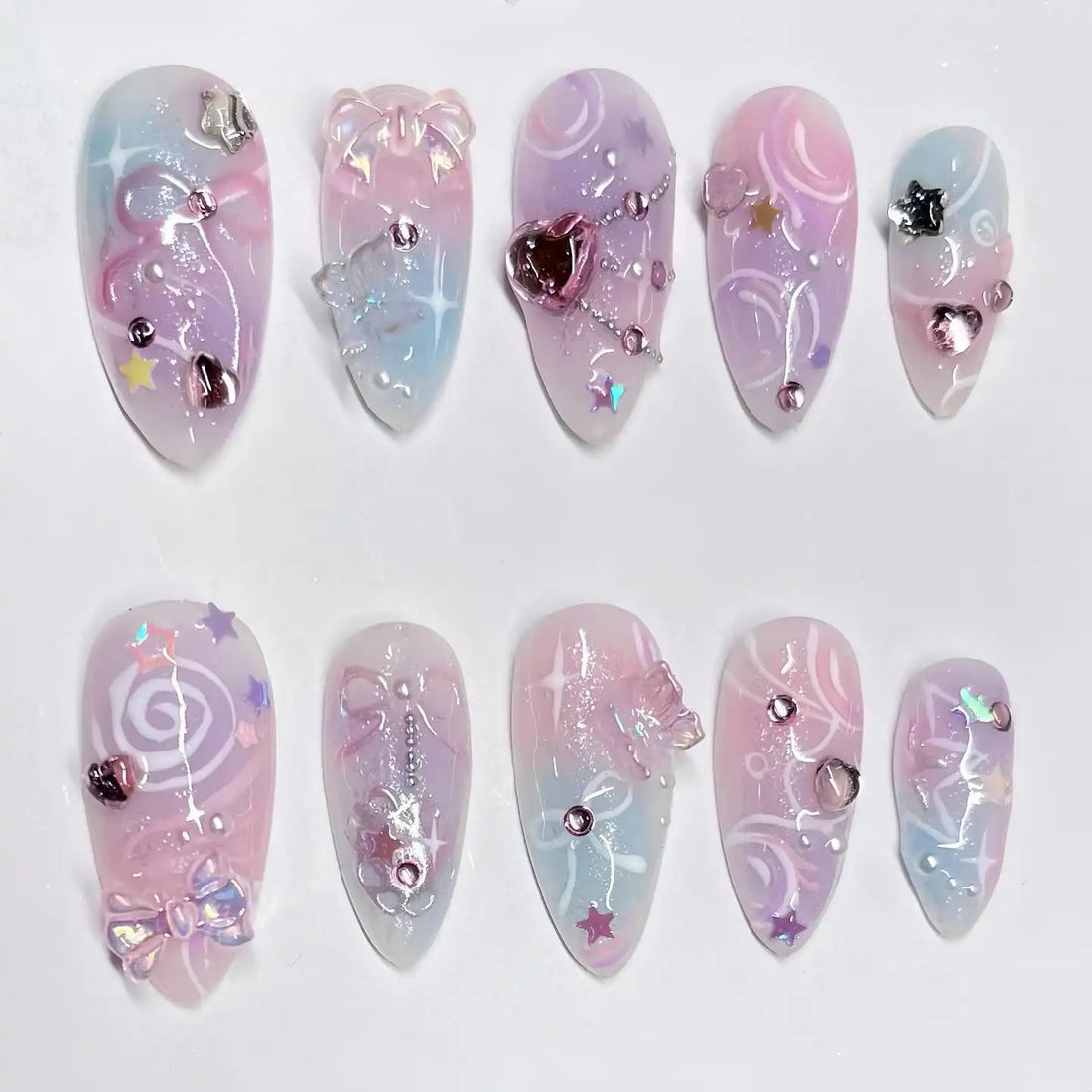 Handmade pastel swirl press-on nails with star, bow, heart, and shimmer fairycore accents.