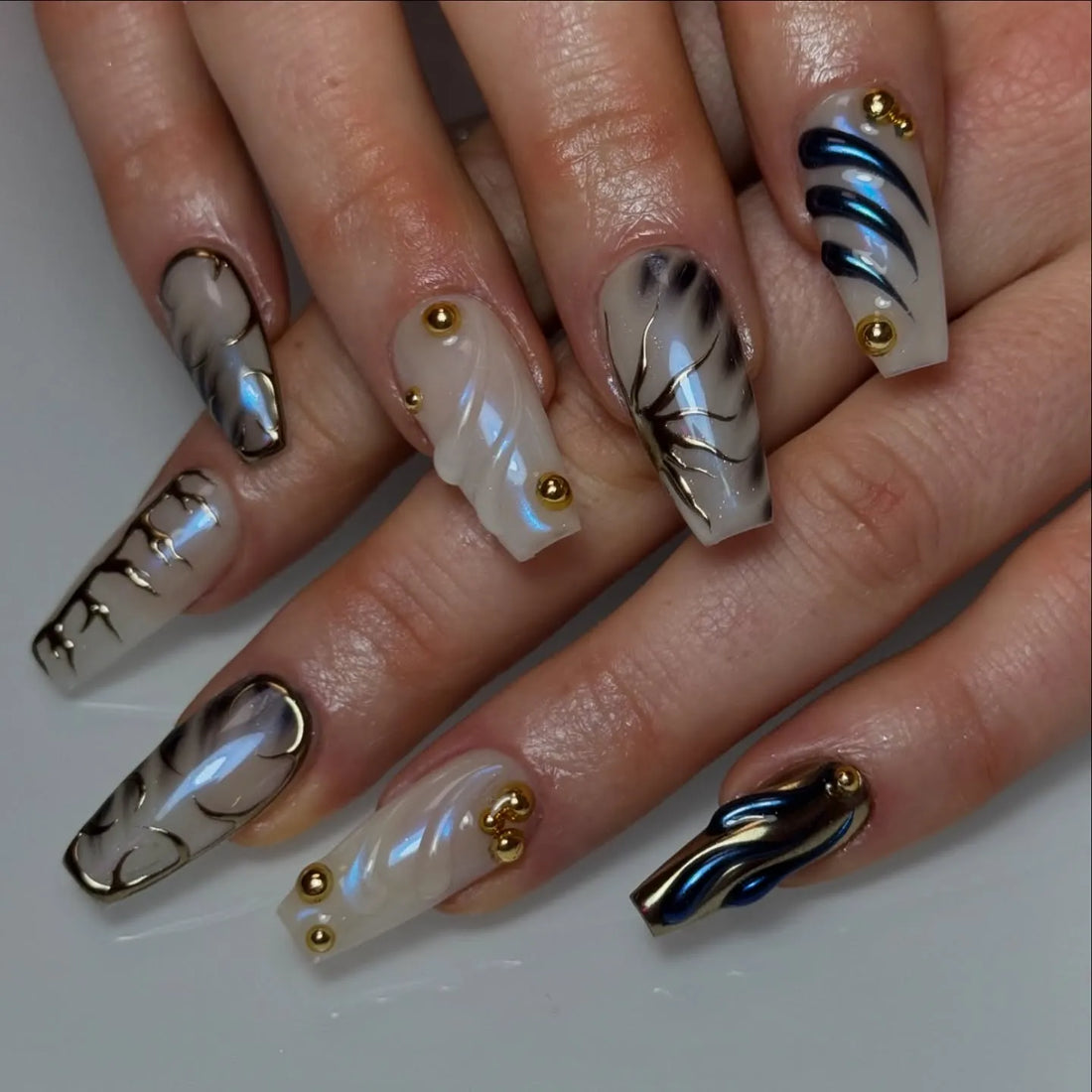 Handmade pearl white 3D swirl gold studded press-on nails with modern abstract design