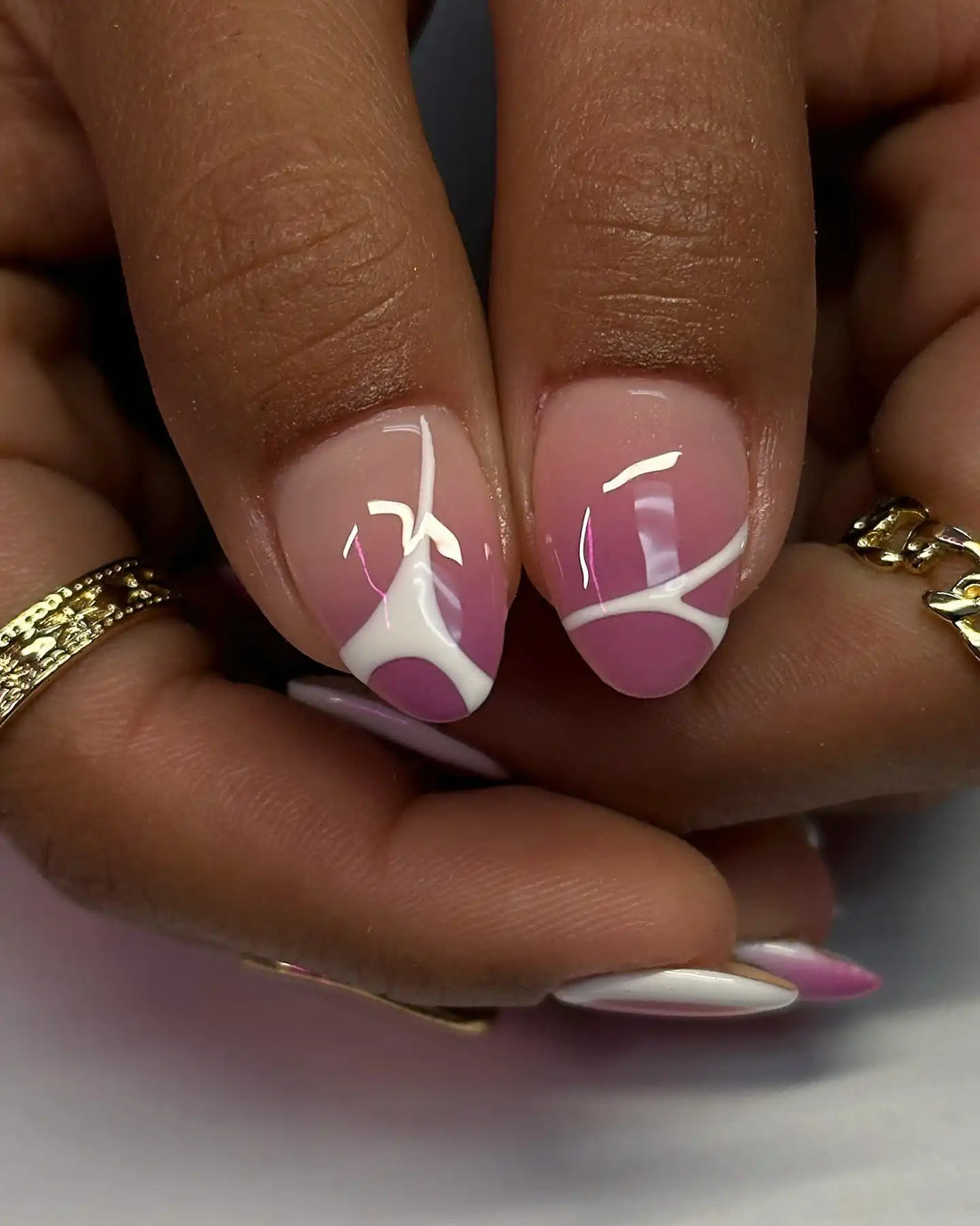 Handmade pink aura press-on nails with gold moon and star accents, white abstract tips.