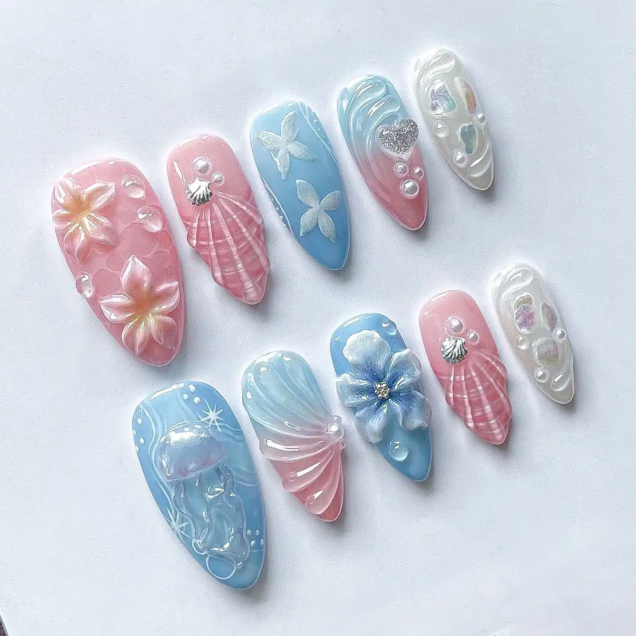 Handmade press-on nails with pink, blue, and white seashell, jellyfish, and floral designs.