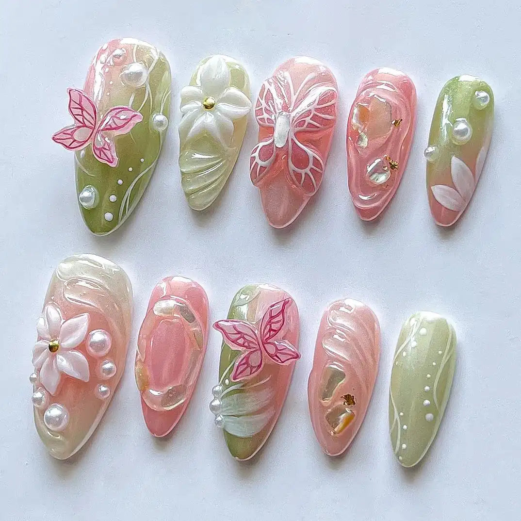 Handmade pink and green press-on nails with 3D butterfly, floral, pearl, and spring designs.