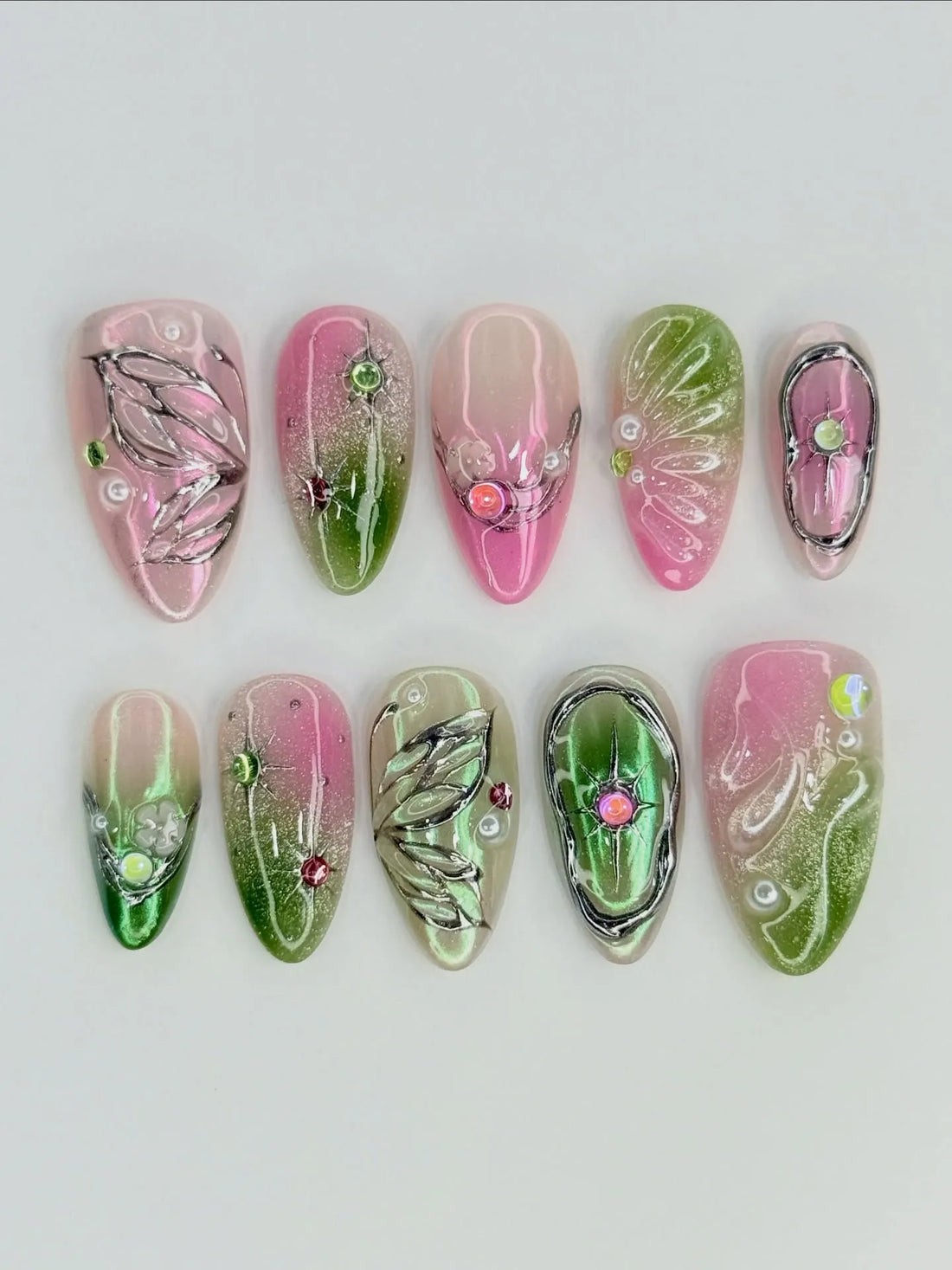 Handmade pink and green butterfly wing press-on nails with chrome details and gem accents.