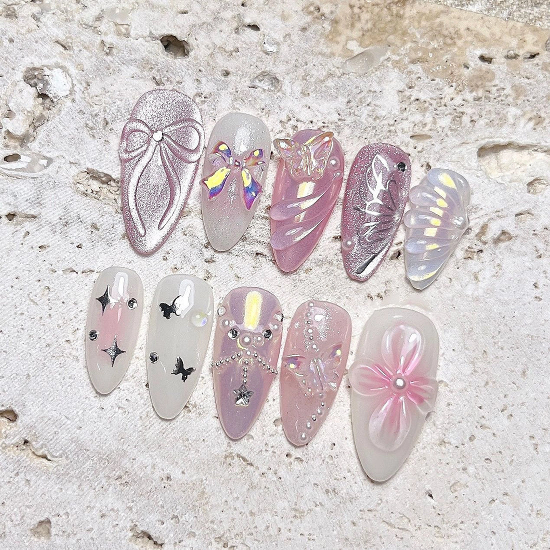 Handmade pink mermaid press-on nails with butterfly, seashell, pearl, and floral 3D designs.