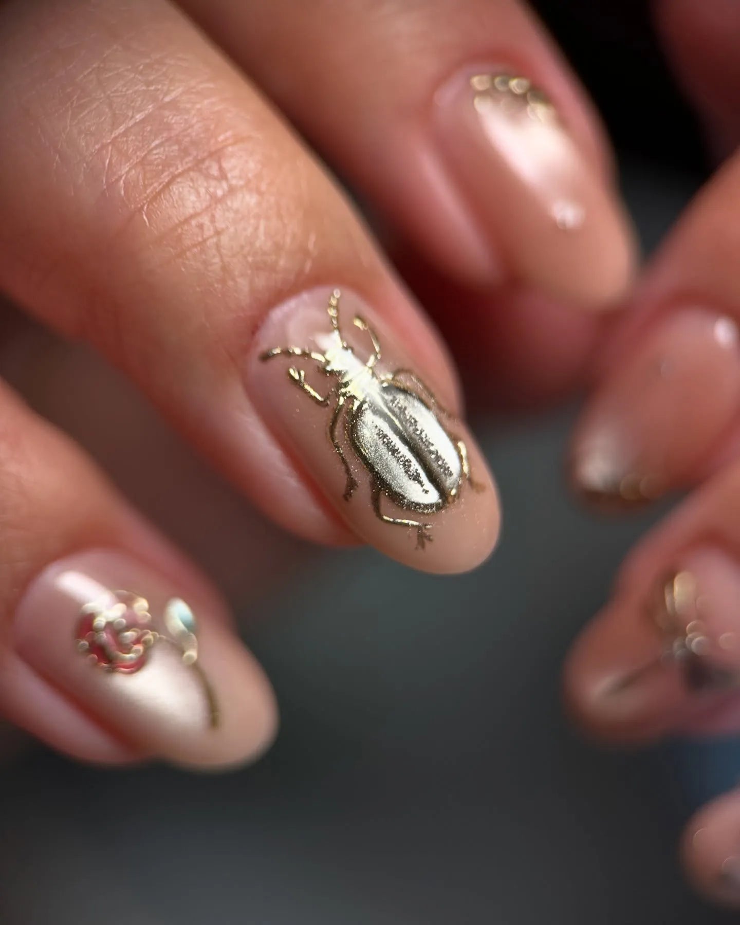 Handmade pink nude press-on nails with gold beetle and gemstone pearl nail art accents