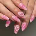 Handmade pink press-on nails with glossy finish, pearl heart accents, and romantic design