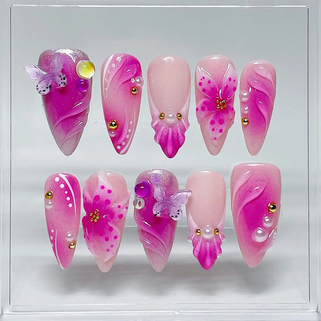 Handmade pink and purple floral butterfly press-on nails with gold studs and pearls.