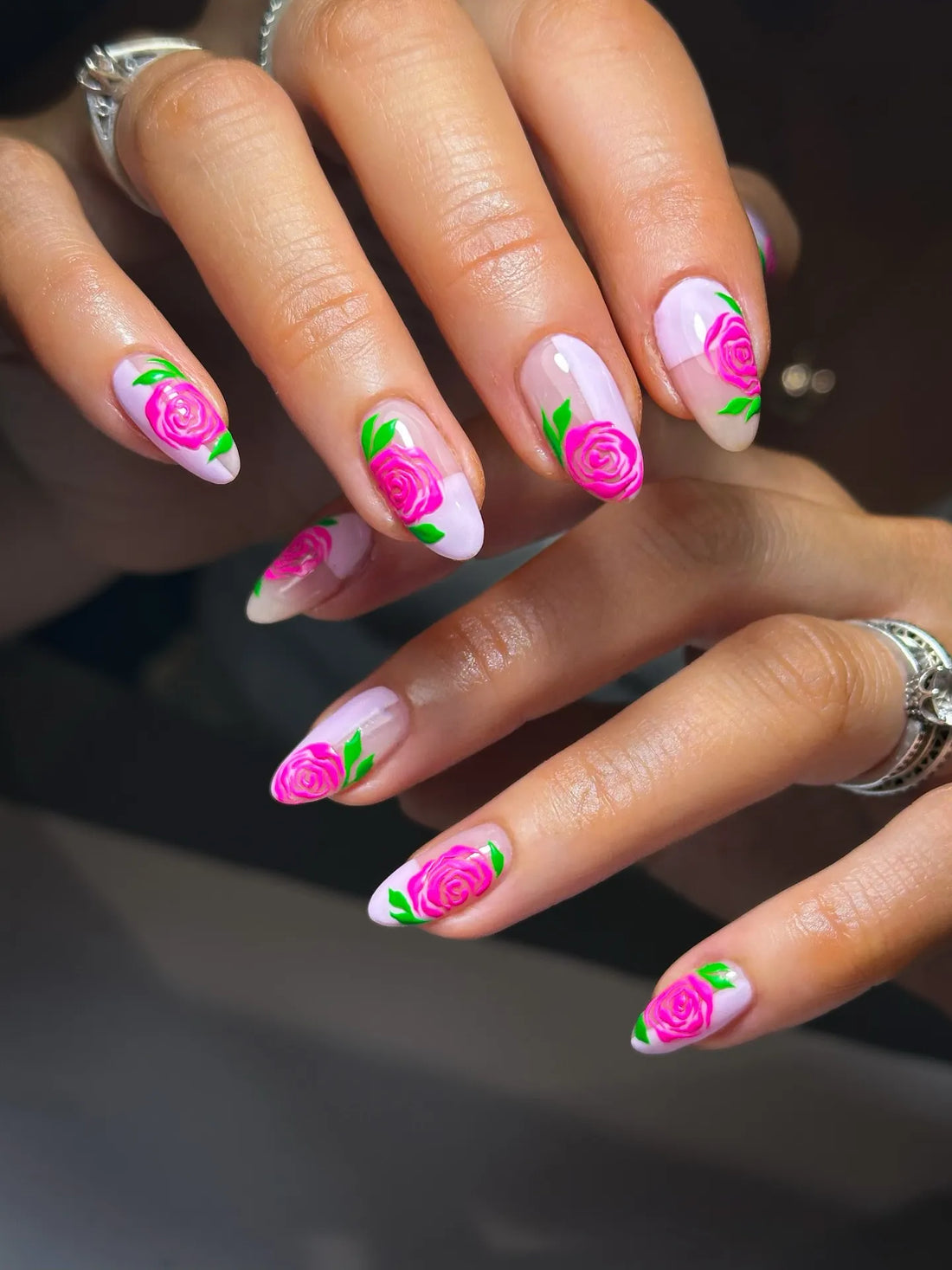 Hand-painted press-on nails with pink rose designs and green leaves on French tips