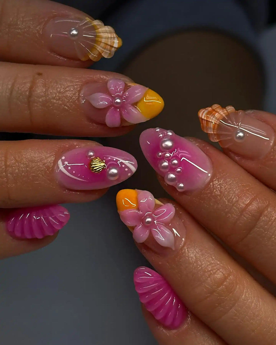 Handmade pink press-on nails with 3D flower, pearl, and seashell designs for summer