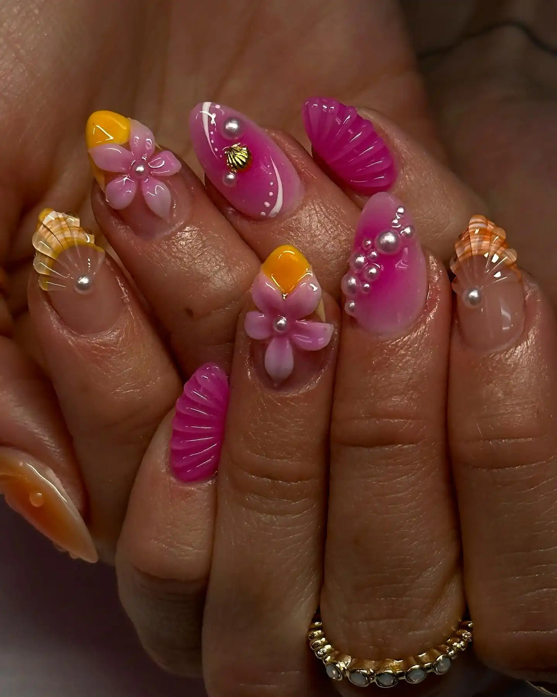 Handmade pink press-on nails with 3D flower, pearl, and seashell designs for summer