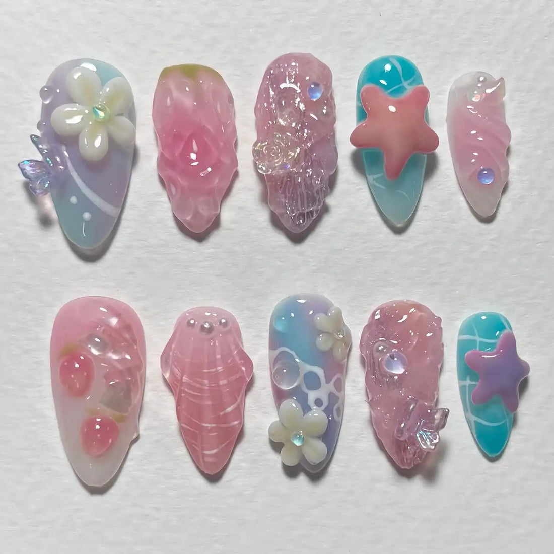 Handmade summer beach press-on nails with pink starfish, jellyfish, seashell, and ocean flower designs.